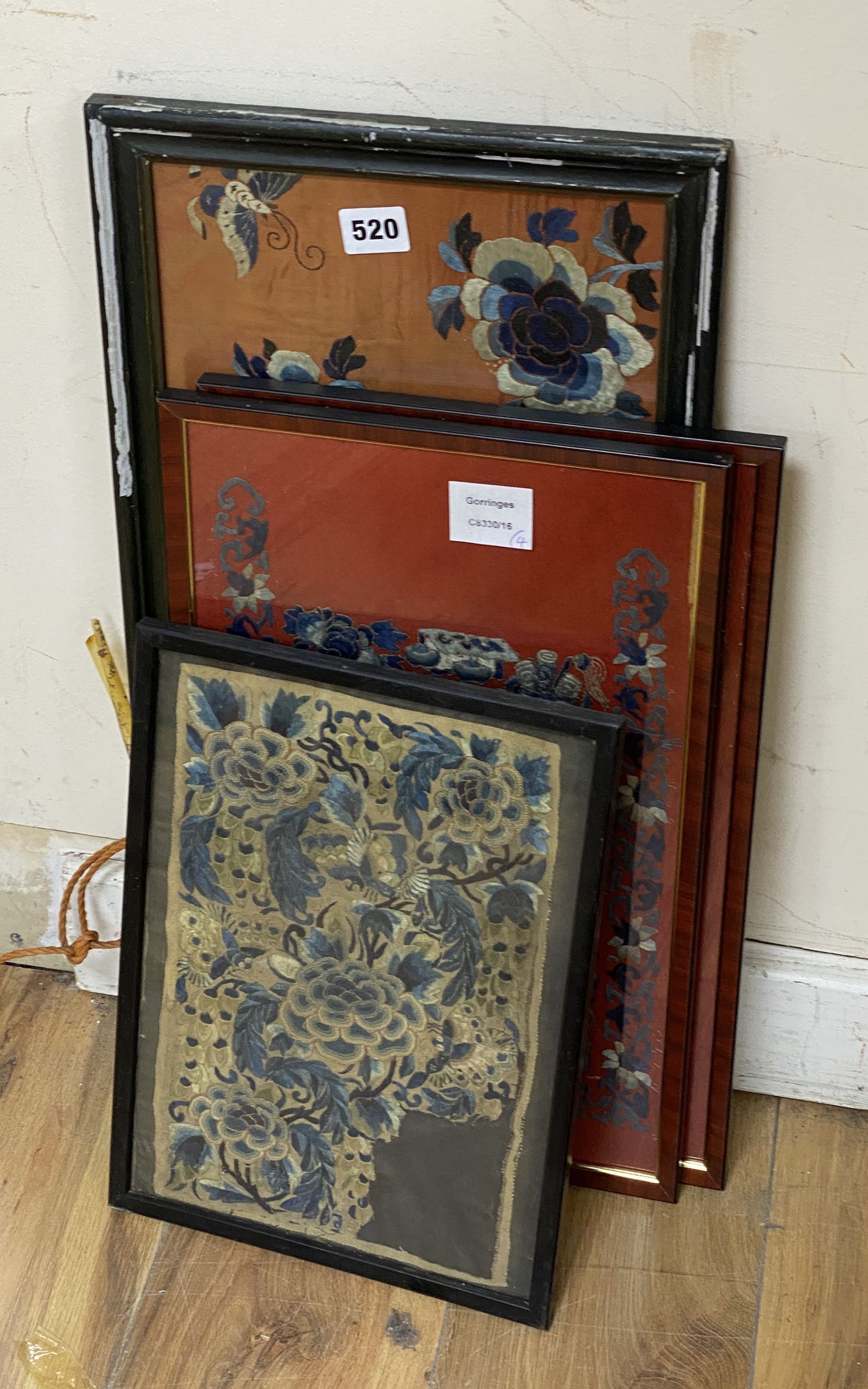 A pair of Chinese embroidered red satin floral panels and two other silk floral panels